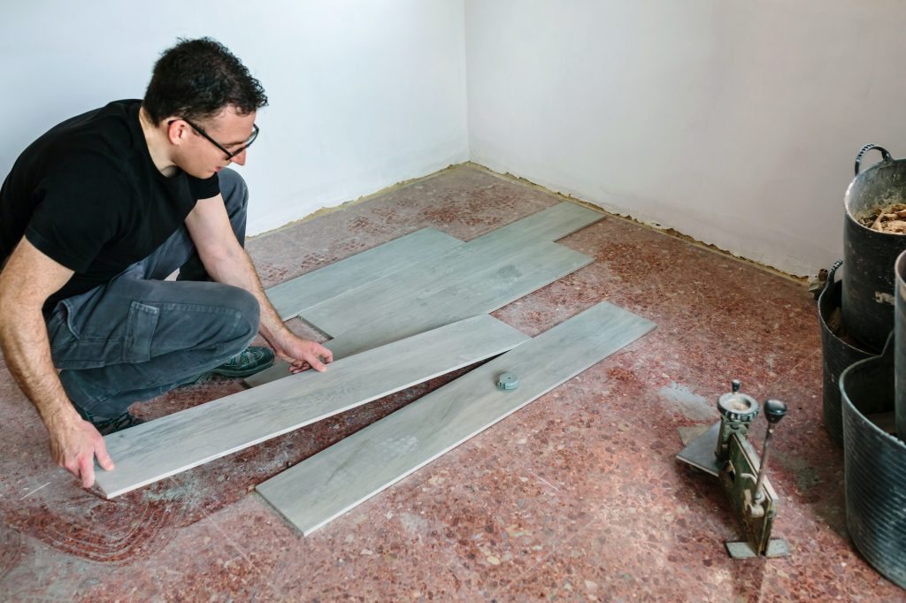 Bricklayer placing tiles to install a floor