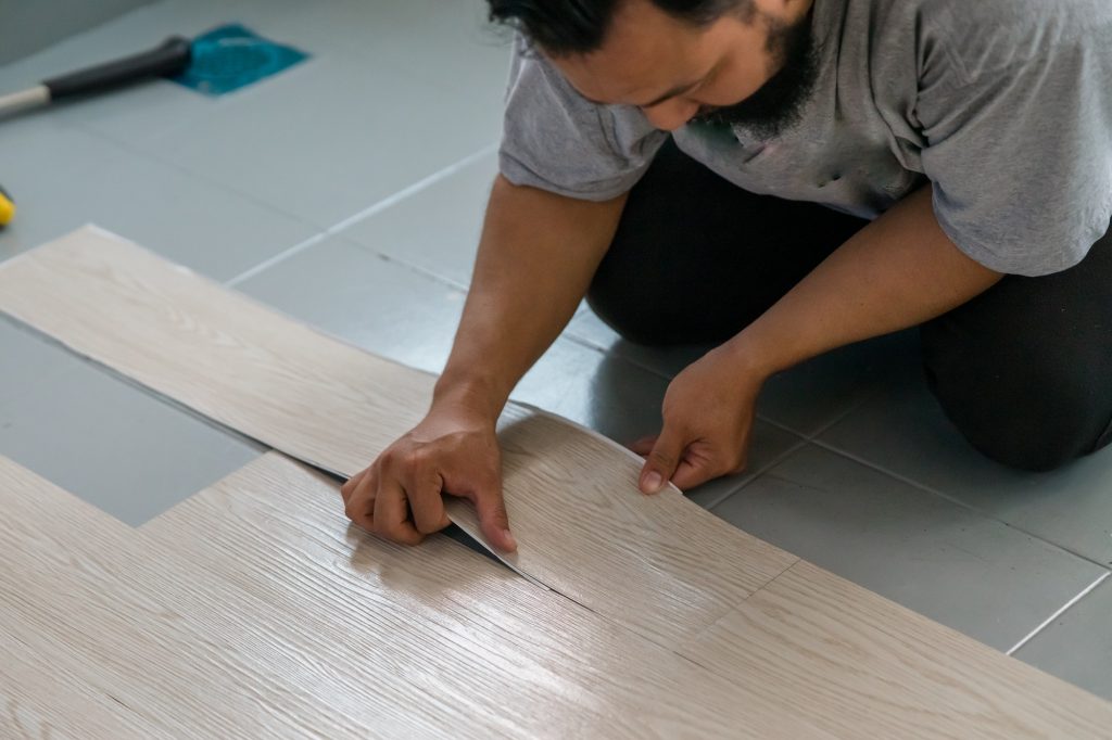 Vinyl floor installation, worker, DIY at home.