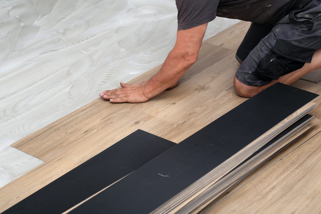 Worker installing new vinyl tile floor